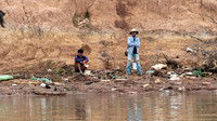 Villagers Waiting for Boat Amongst the Rubbish