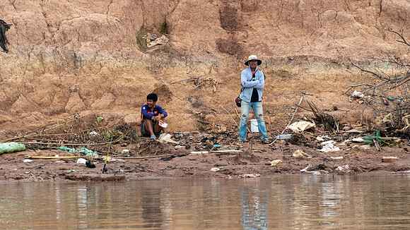Villagers Waiting for Boat Amongst the Rubbish